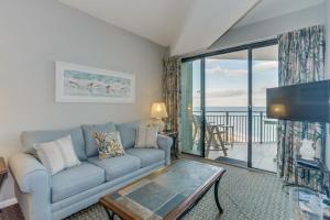 a living room with a couch and a view of the ocean at 2Br Penthouse in the Ocean Forest Plaza in Myrtle Beach