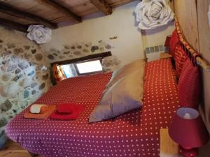 een slaapkamer met een rood bed in een kamer bij Arcogite in Vicdessos