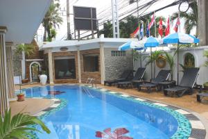 una piscina con sillas y sombrillas junto a un edificio en Orchid Hotel and Spa Kalim Bay, en Patong Beach