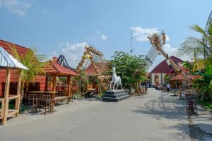 a street with tables and chairs and a statue at RedDoorz @ Kampoeng Etnik Kebumen 2 in Kebumen