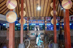 duas bicicletas estacionadas numa sala com postes de bambu em RedDoorz @ Kampoeng Etnik Kebumen 2 em Kebumen