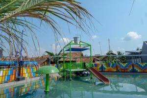 a water park with a slide in a swimming pool at RedDoorz @ Kampoeng Etnik Kebumen 2 in Kebumen