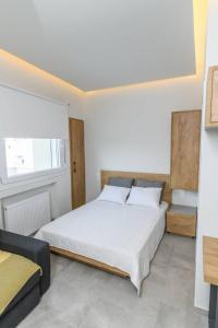 - une chambre avec un grand lit blanc et une fenêtre dans l'établissement Superior modern apartment in the center with view., à Vólos