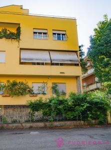 ein gelbes Gebäude mit einem Zaun davor in der Unterkunft Residenza Bolzoni Avio in Parma