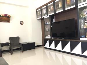 a living room with a television and a chair at Magi House in Magong
