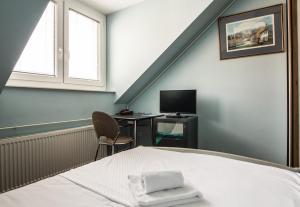a bedroom with a bed and a desk with a computer at Hotel Carlstadt in Karlovac