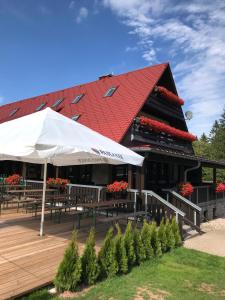 a restaurant with tables and a red roof at Berggasthof Heuberghaus in Friedrichroda