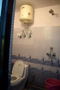 baño con aseo y tanque de agua en Hotel Thakur Ji, en Haridwar