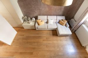 Elena House Gold Apartment في فياريجيو: غرفة معيشة مع أريكة بيضاء وأرضيات خشبية
