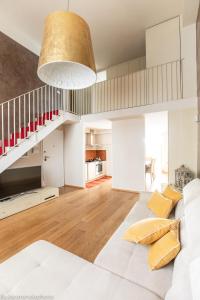a living room with a white couch and a staircase at Elena House Gold Apartment in Viareggio