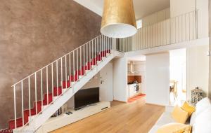 a staircase in a living room with a couch and a television at Elena House Gold Apartment in Viareggio