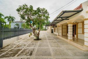 a tree on a sidewalk next to a building at RedDoorz Syariah@Jalan Dr Mansyur Medan in Medan