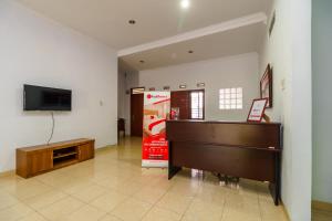 a living room with a piano and a tv at RedDoorz Syariah@Jalan Dr Mansyur Medan in Medan