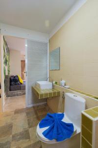 a bathroom with a toilet with a blue bow on it at Baan Chaylay Resort Karon in Karon Beach