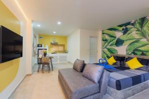 a living room with a couch and a wall with a mural at Baan Chaylay Resort Karon in Karon Beach