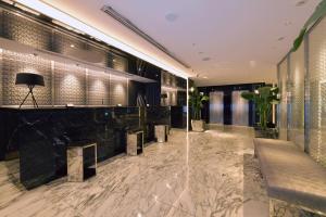a lobby with a marble floor and a bar at Hotel Trusty Nagoya Shirakawa in Nagoya