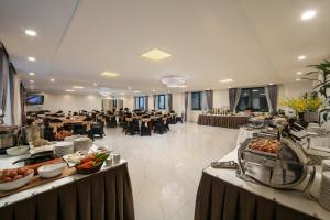 a banquet hall with tables and chairs in a room at Adonis Hotel in Hanoi