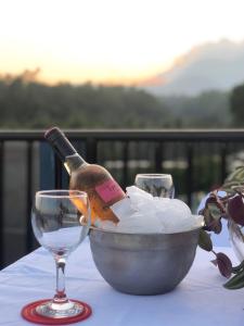 una botella de vino en un tazón sobre una mesa con una copa en Bulusan Tourist Inn en Bulusan