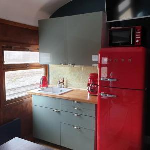 a red refrigerator in a kitchen with a sink at Junamajoitus Tuuri Train Station in Tuuri