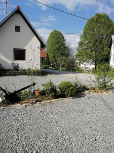 a house with a gravel driveway in front of a house at Apartment House Papa in Vinica