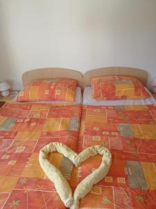 een bed met een hart gemaakt van handdoeken bij Apartment House Papa in Vinica
