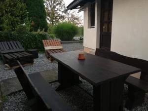 a wooden table and benches in a yard at Apartment House Papa in Vinica +22 photos