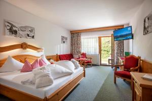 A bed or beds in a room at Hotel Garni Hanslerhof " Urlaub am Bauernhof "