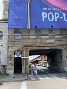 Due persone in piedi sotto un cartello pop-up su un edificio di Rirooms a Fiume (Rijeka)