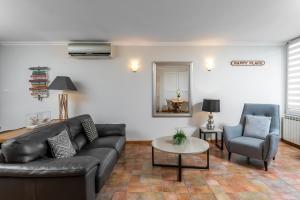 a living room with a couch and a table and a chair at My rima in Antibes