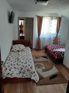 a bedroom with a bed and a man in the mirror at Casa Edy in Călimăneşti
