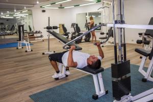 um homem a fazer uma flexão num ginásio em Baia di Conte Resort em Alghero
