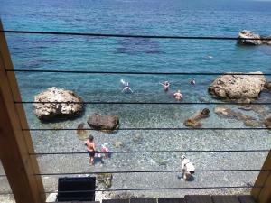 a group of people in the water at the beach at Fatolitis Studios in Masouri