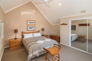 una camera da letto con un letto, una sedia e uno specchio di Bayshore Beachside Resort a Dunsborough