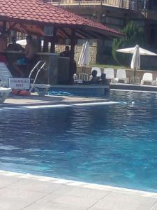 a swimming pool with blue water in a resort at Aprtament 4U in Gabrovo