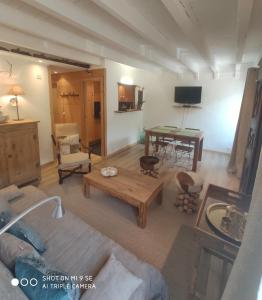 ein Wohnzimmer mit einem Sofa und einem Tisch in der Unterkunft Chez Rosine in Saint-Sauveur-sur-Tinée