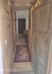 a hallway with a large wooden door and a rug at Chez Rosine in Saint-Sauveur-sur-Tinée