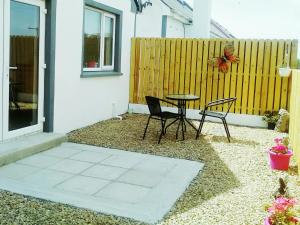 a patio with a table and chairs and a fence at Casa Tara in Lahinch