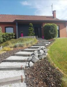 einen Garten mit Felsen und ein Haus in der Unterkunft Chez Marianne in Wailly