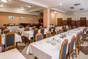 a dining room with white tables and chairs at Hotel Carlstadt in Karlovac +40 photos