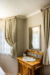 a bathroom with a sink and a mirror at Van Dykshuis Guest House in Heidelberg