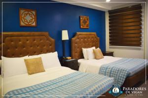 two beds in a hotel room with blue walls at Paradores de Vigan in Vigan