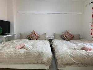 two beds sitting next to each other in a bedroom at GOLDHOUSE Shinosaka 303 in Osaka