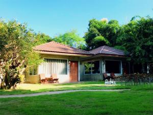 a house with a table and chairs in a yard at Villa De Bua Resort Nan in Nan