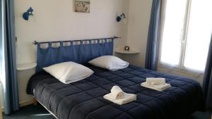 a bedroom with a blue bed with towels on it at Le Concept Hotel in Les Portes