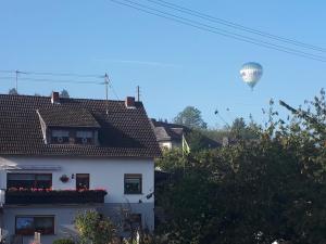 BurgbrohlにあるKleines Glückの白い家の上空を飛ぶ熱気球