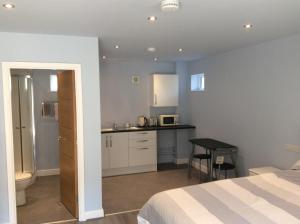 a bedroom with a bed and a small kitchen at Swans Nest in Holmfirth