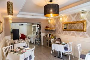 a restaurant with white tables and chairs and a mirror at Hotel Henri IV in Sully-sur-Loire