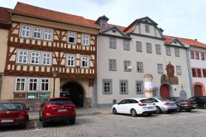 a group of cars parked in a parking lot in front of buildings at Haus zum Römer in Arnstadt