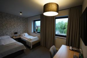 アレクサンドルフ・ウツキにあるKamienica nr 6のベッド2台と窓が備わるホテルルームです。