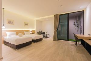 um quarto de hotel com duas camas e uma secretária em Madison Bangkok Hotel em Bangkok